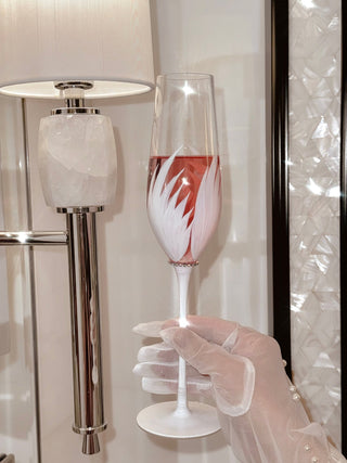 Feather Bliss Champagne Flute filled with sparkling pink rosé, enjoyed during a luxurious honeymoon.