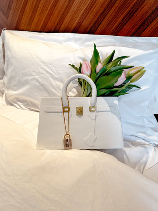 Victoria Handbag Resin Vase placed atop plush linens.