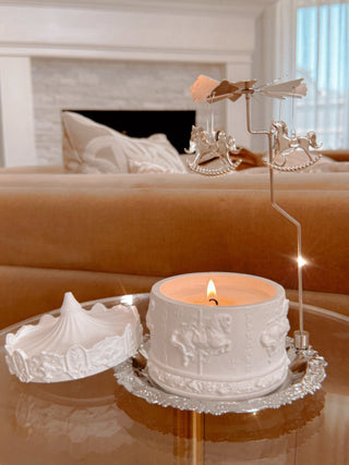 A Starry Sky Carousel Candle Set of 3 atop a luxurious, modern acrylic side table.