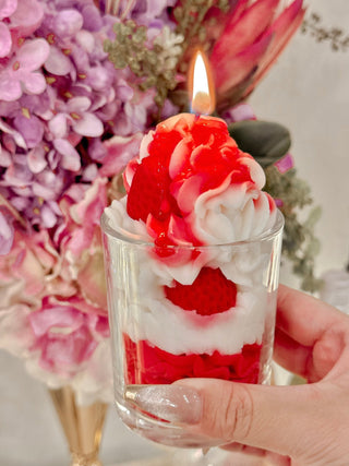 A woman holding a Strawberries & Cream Candle.