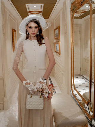Woman posing in regal hallway with the Scarlett Handbag Resin Vase in Beige.