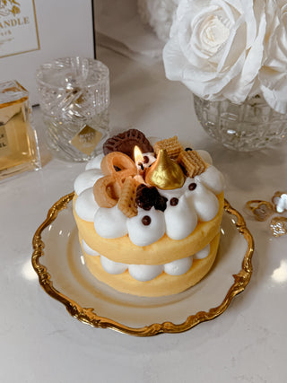 The Honey Gold Gâteau Cake Candle on a marble dining table.