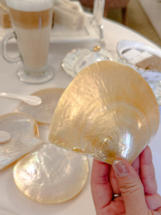Woman showing the back of a luxurious clamshell dessert plate.