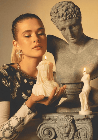 A woman posing with the 'Amour, Anaïs' candle and Venus Candle.