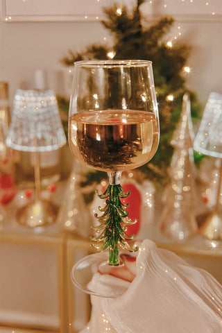 A Merry Christmas Wine Flute in front of cheerful holiday decor.