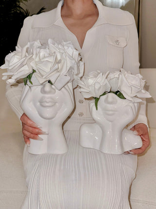 A woman posing with the “Her” & Angelica Ceramic Vase Set of 2 filled with large white florals.