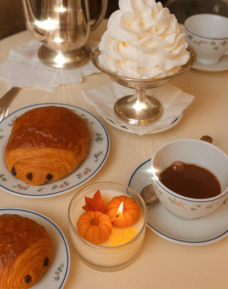 Vela con hojas y calabazas cayendo
