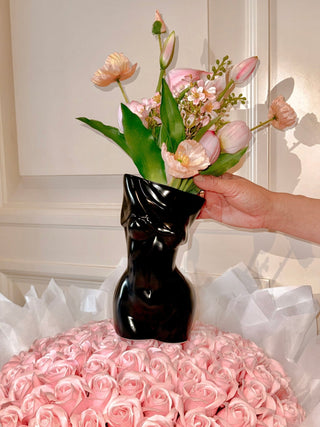 The Feminine Ceramic Vase in Black atop a $2000 pink bouquet.