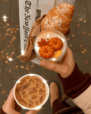 Vela con hojas y calabazas cayendo