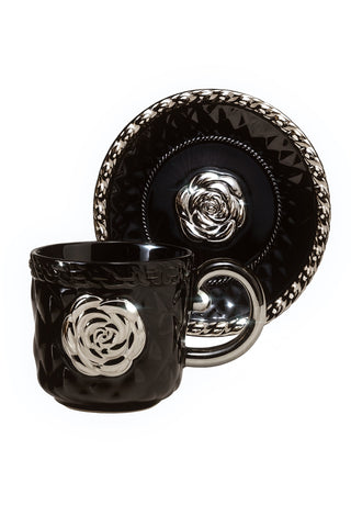 Black ceramic mug and plate set with rose design on a white background.