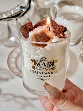 A woman holding a lit Chocolate Bear & Cookies Latte Candle.