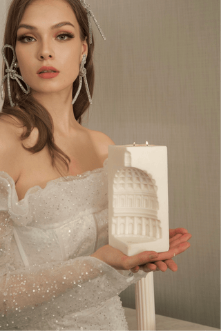 A woman poses with the ‘When in Rome’ 2-Wick Candle, handcrafted with premium beeswax and soy wax.