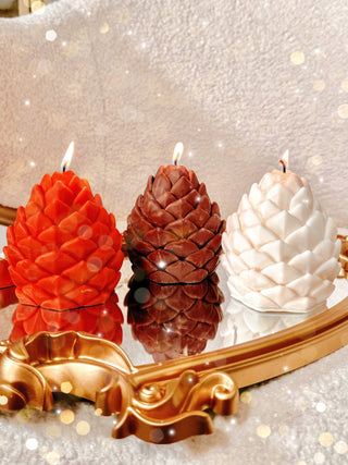 Holiday Lavish Pinecones Candle Set of 3 featuring pumpkin orange, pinecone brown, and sculpture white.