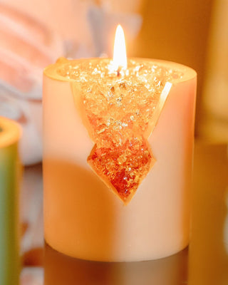 A lit 18K Gold Citrine Crystal Candle showing off its quartz-like gel wax.