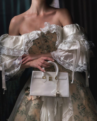 A woman in a stunning floral dress holding a Victoria Handbag Resin Vase.
