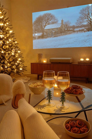 A couple enjoying the Merry Christmas Wine Flute Set with cinnamon rolls and popcorn.