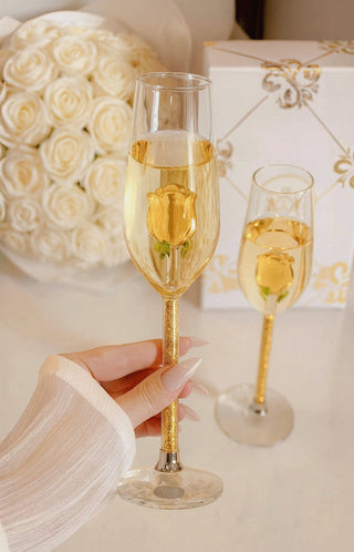 A woman admires the wine inside her Golden La Vie En Rose Champagne Glass.