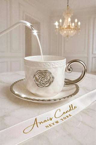 Camellia teacup with rose design being filled with milk on a marble surface.