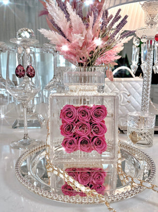 Everlasting Roses in Parfum Box - Plum surrounded by glass, crystal, and silver decor.
