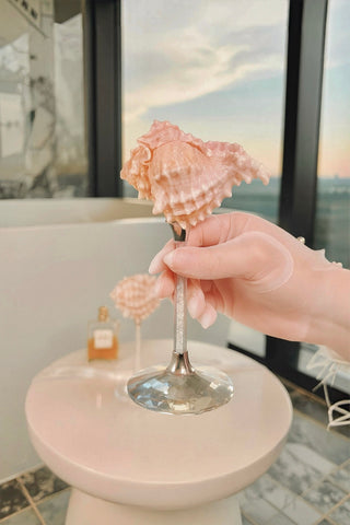 Woman enjoying a Coppa Sirena Seashell Cup™️ in her luxurious bathroom.