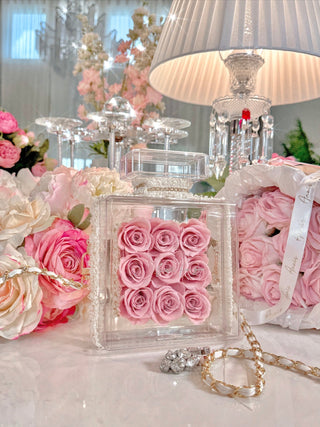 Everlasting Roses in Parfum Box in French Rose Pink surrounded by luxurious decor.