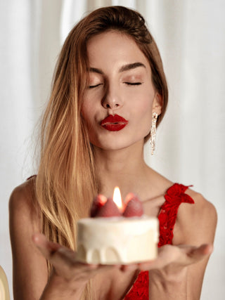 A woman holding an Anaïs Strawberry Shortcake Candle.