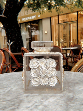 Everlasting Roses in Parfum Box - White placed atop a round marble veined dining table.