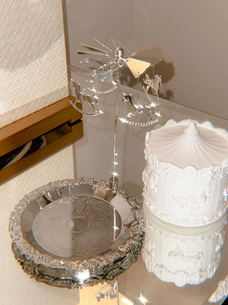 The Starry Sky Carousel Candle, featuring the horse and carriage carousel, powered by its lit flame.