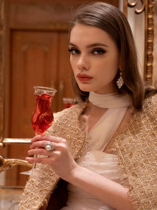 A woman sipping champagne from The Lady Glass Cup.