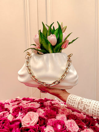 Sylvie Cloud Handbag with Gold Chain Resin Vase atop a pink and red bouquet.