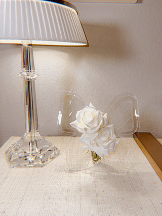 The Château Butterfly Acrylic Vase atop a luxurious yellow credenza.