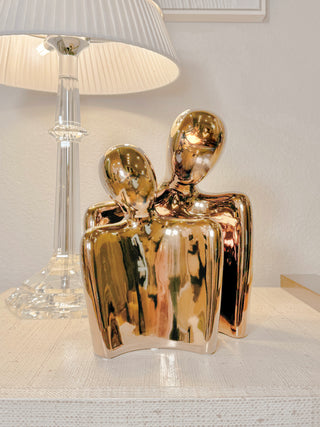 'Forever Us' Romantic Couple Statue - XXL Gold Electroplated next to a crystal lamp.