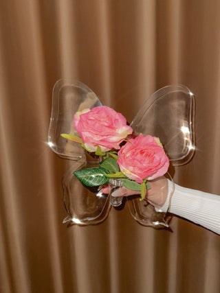 Château Butterfly Acrylic Vase decorated with faux pink blooming flowers.