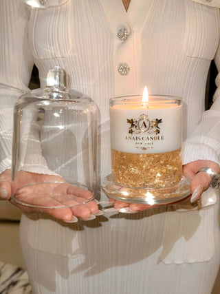 A close up of a woman posing with the Majesté Dorée Gold Leaf Candle.