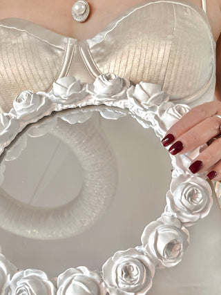 A model gently displays the White Roses Mirror Tray.