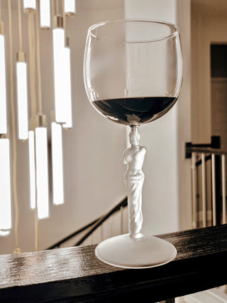 The Venus Goddess Sculpture Wine Flute Set next to a spiral staircase.