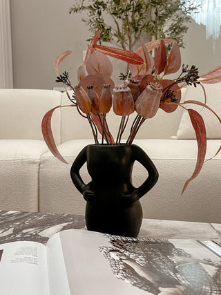Mia Body Ceramic Vase in Black decorated atop a mansion's marble coffee table.