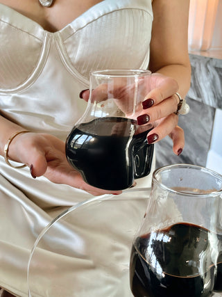 A woman drinking wine from her Lexi Female Glass Cup Set.