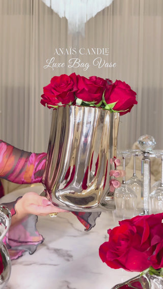 A woman holding a Luxe Bag Vase - Silver Electroplated.