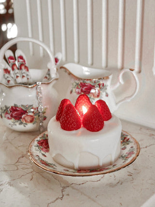 Anaïs Strawberry Shortcake Candle on a vintage tea time plate.