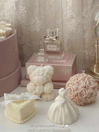 The Flower Romance in French Rose Pink, surrounded by other Anaïs Candles.
