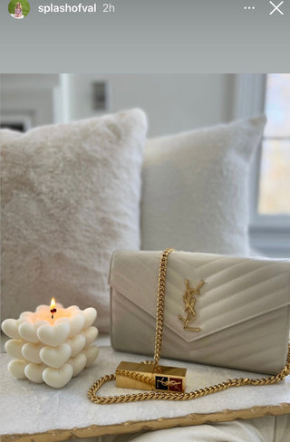 “I Heart You” Candle next a luxury handbag.