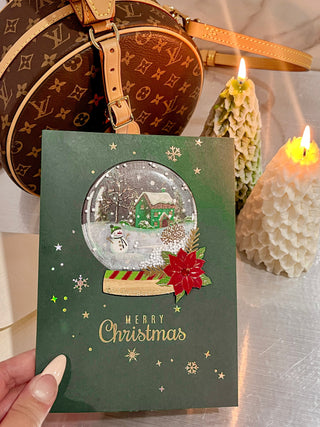 Shake-To-Snow Holiday Card next to Anaïs Candle's Christmas Tree Candles.