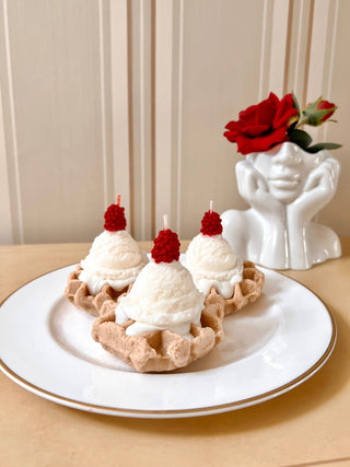 A Belgian Waffles & Ice Cream Candle on a white plate.