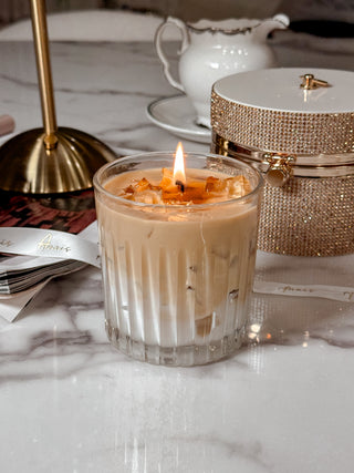 A lit Iced Caffè Candle on a beautiful marble dining table.