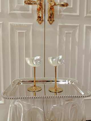 Seashell Enchanté Cup™️ Set of 2 in front of luxurious French doors.