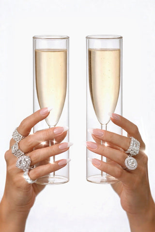 Two hands holding Maeve Double Layered Glass Cup Set of 4 in a 5 star hotel.