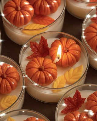 Vela con hojas y calabazas cayendo 