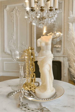 The Venus Candle in Sculpture White in a classy palace-like setting with marble and crystals.