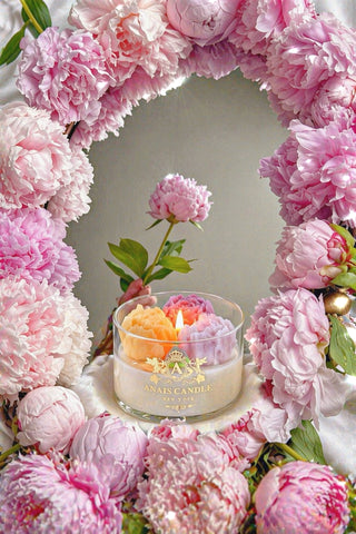 Peony Bouquet Candle surrounded by violet, pink and purple blooming peonies